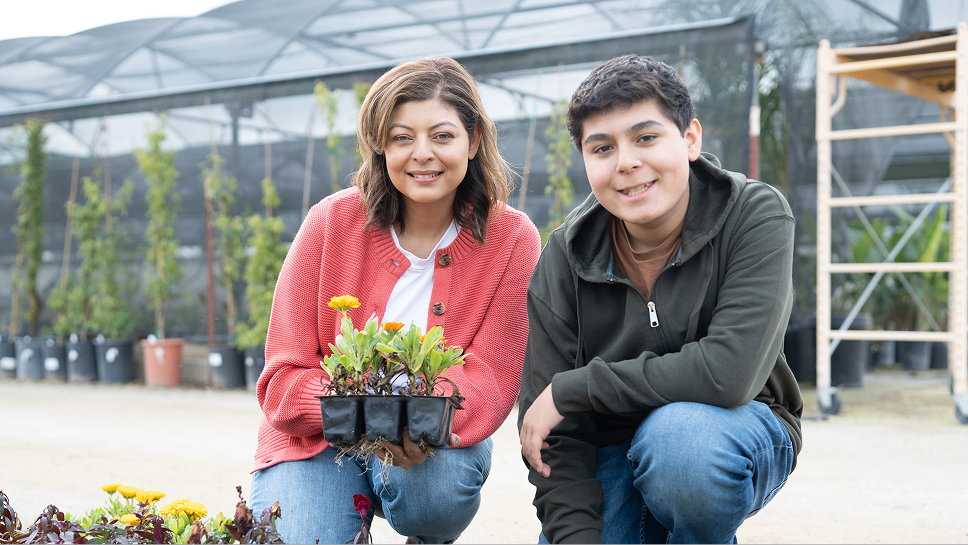 Image of a boy and mother kneeling in a garden center